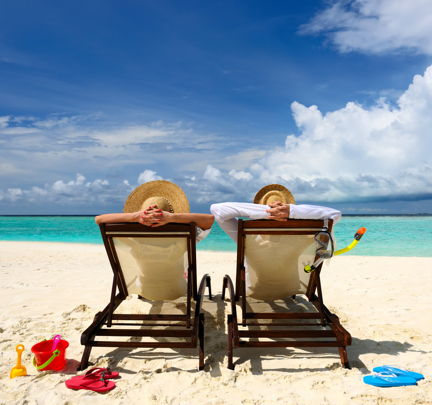 Two couple with a hat relaxing by the beach on a sunny day